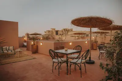 a patio with a table and chairs and umbrellas at Riad l'Esprit des Patios & Spa in Marrakech