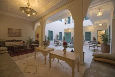 a large living room with tables and chairs at Riad l'Esprit des Patios & Spa in Marrakech
