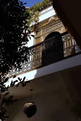 a building with a balcony with a light hanging from it at Riad Dar Dallah in Marrakech