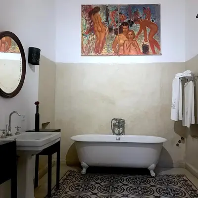 a bathroom with a tub and a sink and a painting at Riad Dar Dallah in Marrakech