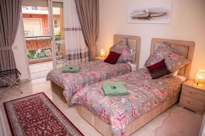 a bedroom with two beds and a balcony at Beautiful, great equipped 122 m holiday apartment near Majorelle Garden and Gueliz with pool views and a large balcony and terrace in Marrakech