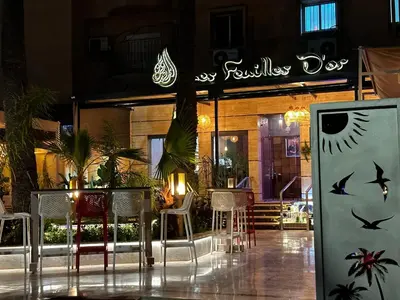 a restaurant with a table and chairs and a sign at Beautiful, great equipped 122 m holiday apartment near Majorelle Garden and Gueliz with pool views and a large balcony and terrace in Marrakech