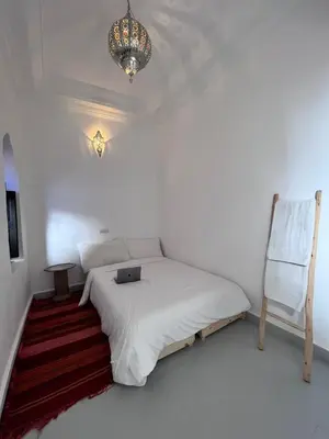 a bedroom with a bed with a laptop on it at Riad Black Doors in Marrakech