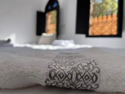 a close up of a white blanket on a bed at Riad Black Doors in Marrakech