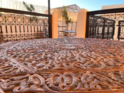 a wooden table sitting on top of a balcony at Riad Black Doors in Marrakech