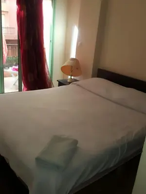 a bedroom with a white bed and a window at Propre appartement à loué pour les familles in Marrakech