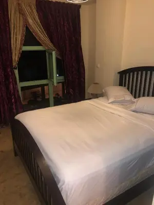 a large white bed in a bedroom with a television at Propre appartement à loué pour les familles in Marrakech