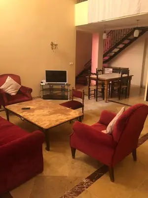 a living room with couches and a table and a piano at Propre appartement à loué pour les familles in Marrakech
