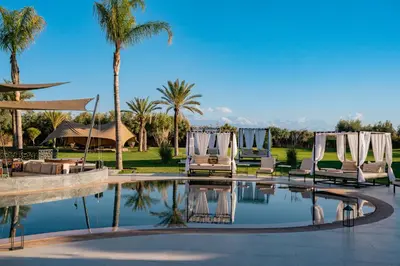 a resort with a pool with chairs and palm trees at Palais Anthea Boutique Hotel & Spa in Marrakech
