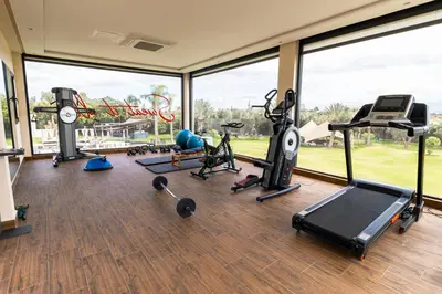 a gym with cardio equipment in a room with a large window at Palais Anthea Boutique Hotel & Spa in Marrakech