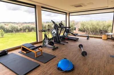 a gym with exercise equipment and large windows at Palais Anthea Boutique Hotel & Spa in Marrakech
