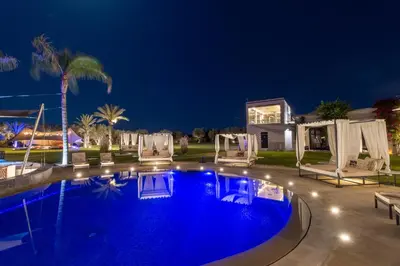 a swimming pool at night with chairs and a house at Palais Anthea Boutique Hotel & Spa in Marrakech