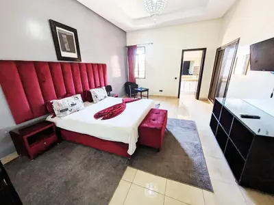 a bedroom with a large bed with a red headboard at Villas Green in Marrakech