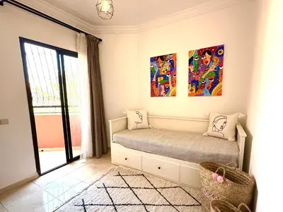 a room with a bed with two paintings on the wall at Appartement Dalila in Marrakech