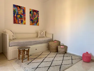 a room with a bench and two paintings on the wall at Appartement Dalila in Marrakech