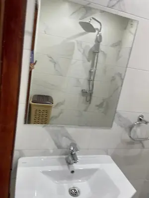 a bathroom with a white sink and a mirror at Appartement dans résidence avec piscine in Marrakech