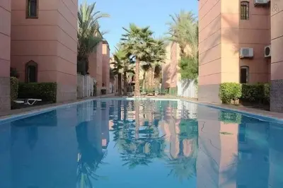 a swimming pool in the middle of a building at Appartement dans résidence avec piscine in Marrakech