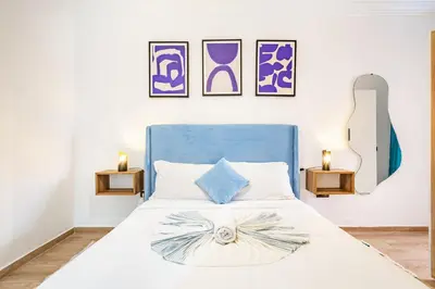 a bedroom with a white bed with a blue headboard at Magnificent Apartment in Gueliz - 100% Equipped in Marrakech