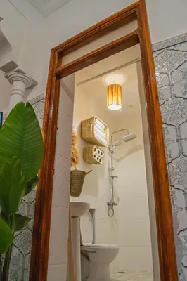 a mirror in a bathroom with a toilet and a light at Riad Fz Marrakech in Marrakech