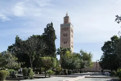 a tall tower with a clock on it in a park at Magnifique Duplex à Marrakech in Marrakech