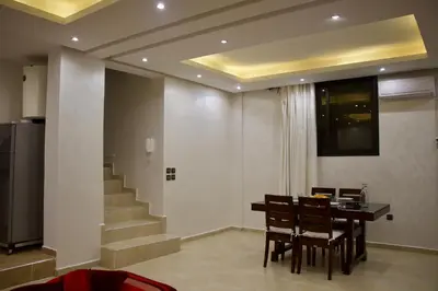 a dining room with a table and chairs and stairs at Magnifique Duplex à Marrakech in Marrakech