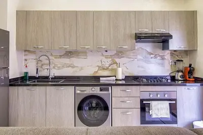 a kitchen with a washing machine and a sink at Les Jardins Sakar - Marrakech - Deux Chambres Exceptionnelle in Marrakech