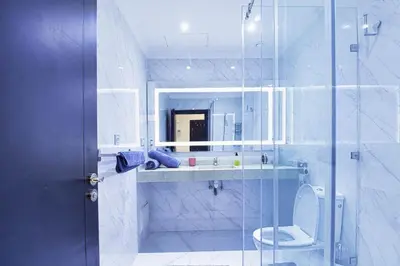 a bathroom with a toilet and a glass shower at Les Jardins Sakar - Marrakech - Deux Chambres Exceptionnelle in Marrakech