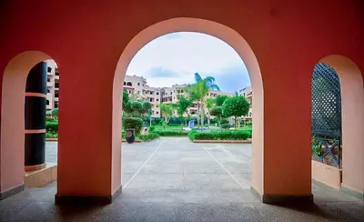 a red wall with an archway in a courtyard at Les Jardins Sakar - Marrakech - Deux Chambres Exceptionnelle in Marrakech