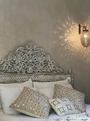 a bed with an ornate headboard and pillows at Riad with Outdoor Swimming Pools in Marrakech