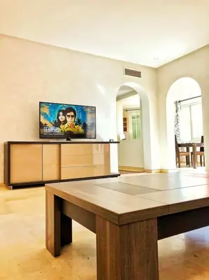 a living room with a table and a tv at Magnifique Duplex En Plein Hivernage à Marrakech in Marrakech
