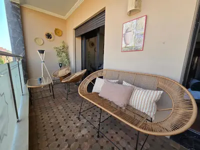 a wicker bench with two pillows on a balcony at Bagatelle House 2 in Marrakech