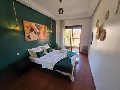 a bedroom with a bed in a green wall at Bagatelle House 2 in Marrakech