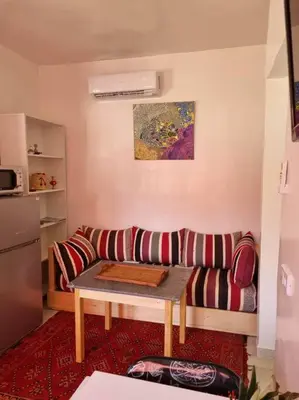 a living room with a couch and a table at proche aéroport, idéal pour travailler in Marrakech