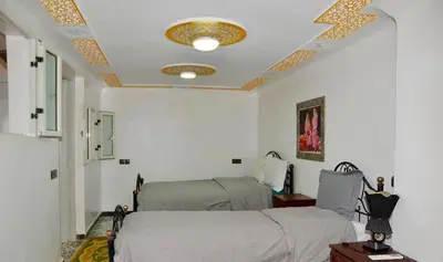 a bedroom with two beds and a ceiling with a star at Araf House in Marrakech
