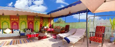 a tent with beds and chairs on a patio at Araf House in Marrakech