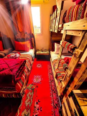 a room with two bunk beds and a red carpet at Appartement funny house a place jamaa el fna de marrakech in Marrakech