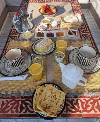 a table topped with plates of food and toast at Riad Dar Marrakcha in Marrakech