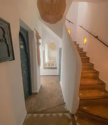 a hallway with stairs and a green door at Riad Dar Marrakcha in Marrakech