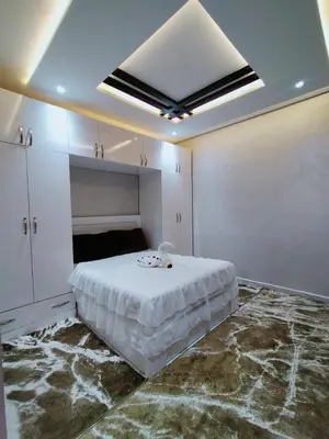 a white bedroom with a large bed and a ceiling at Appartement de luxe à 7 min de Centre de ville a petit prix pour passer un agréable séjour in Marrakech