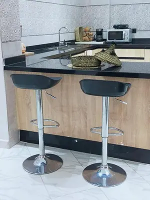 a kitchen with two bar stools in front of a counter at Appartement de luxe à 7 min de Centre de ville a petit prix pour passer un agréable séjour in Marrakech