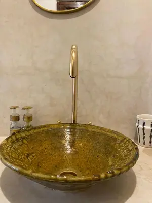 a gold bathroom sink sitting on top of a counter at Riad Musa in Marrakech