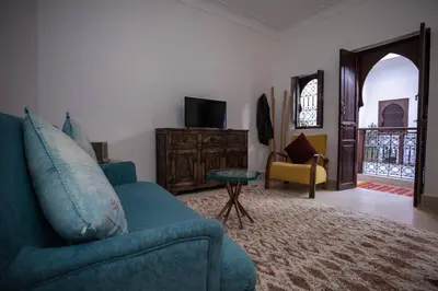a living room with a blue couch and a table at Paisible riad privatif au cœur de Marrakech in Marrakech