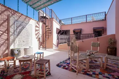a patio with chairs and tables on a building at Paisible riad privatif au cœur de Marrakech in Marrakech