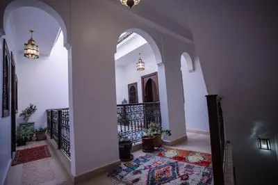 a hallway with white walls and a staircase with a rug at Paisible riad privatif au cœur de Marrakech in Marrakech