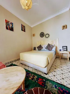 a bedroom with a large bed and a table at Happy Marrakchy in Marrakech