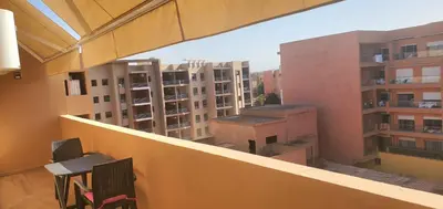 a balcony with two chairs and some buildings at Appartement tout neuf en plein centre de Marrakech in Marrakech