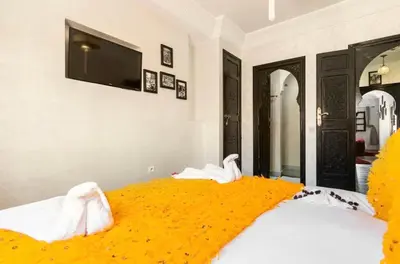 a bedroom with two beds and a flat screen tv at Riad Dar IMANE in Marrakech
