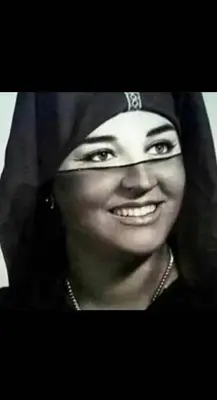 a woman wearing a hijab smiles at the camera at Riad Dar IMANE in Marrakech