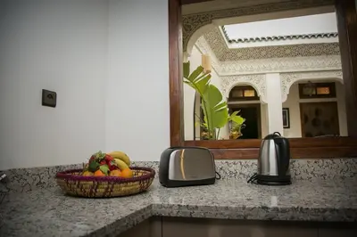 a bowl of fruit on a counter in front of a mirror at Riad Sabria in Marrakech