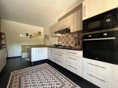a kitchen with white cabinets and a black appliances at Marrakech M Avenue terrasse jardin in Marrakech